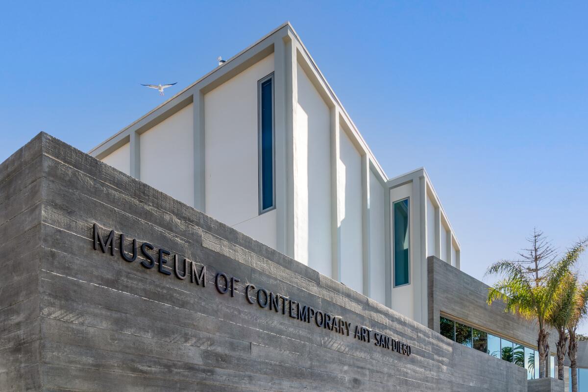 An upward angle image shows a board-formed concrete wall bearing the name of the museum.