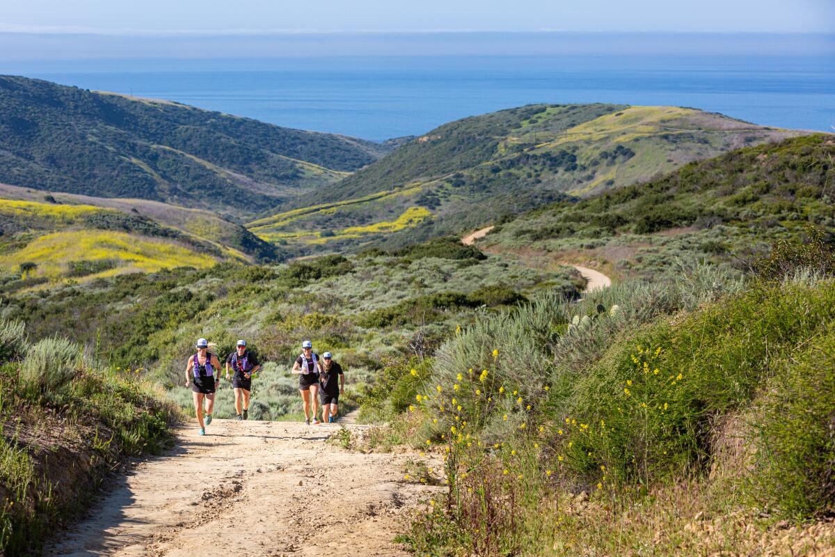 Runners make their way up a hill on the Newport Coast course during the 2022 John Wayne Grit Series.