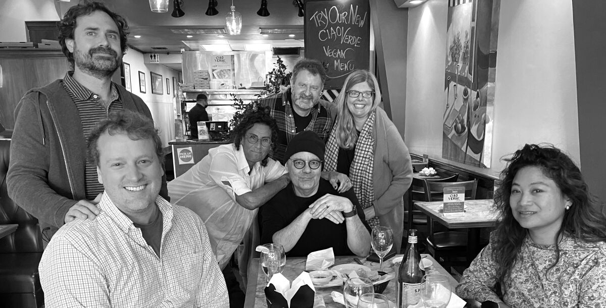 A black-and-white image of seven writers in a restaurant.