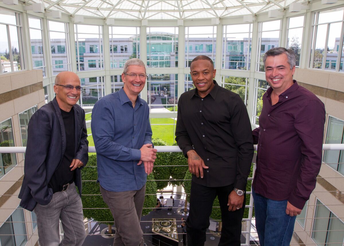 Music entrepreneur and Beats co-founder Jimmy Iovine, left, Apple CEO Tim Cook, Beats co-founder Dr. Dre and Apple Senior Vice President Eddy Cue gather at Apple's headquarters in Cupertino, Calif.