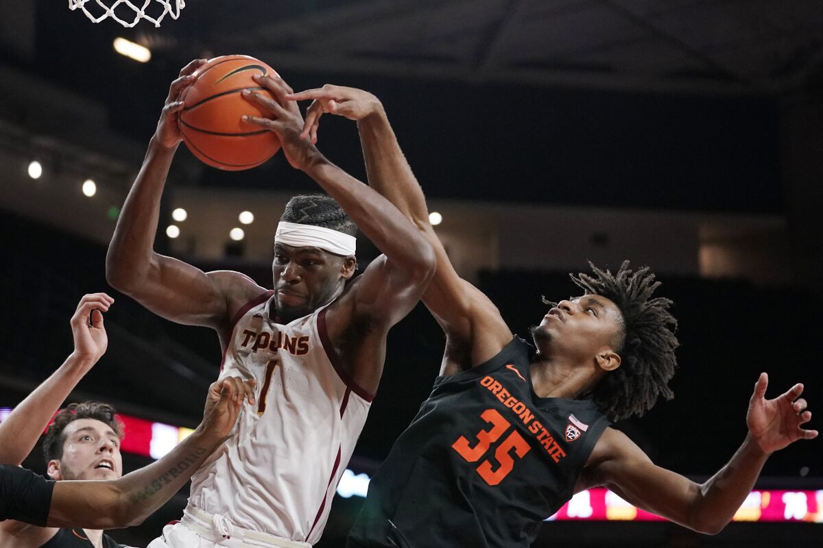 Southern California forward Chevez Goodwin, left, grabs a rebound away from Oregon State forward Glenn Taylor Jr. during the second half of an NCAA college basketball game Thursday, Jan. 13, 2022, in Los Angeles. (AP Photo/Mark J. Terrill)