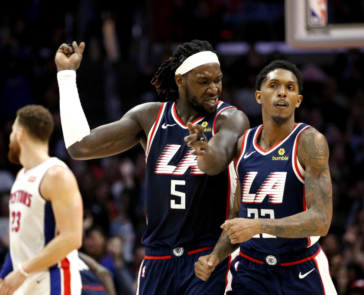Clippers forward Montrezl Harrell, left, celebrates after Lou Williams, right, made a three-pointer against the Pistons on Jan. 12 at Staples Center.