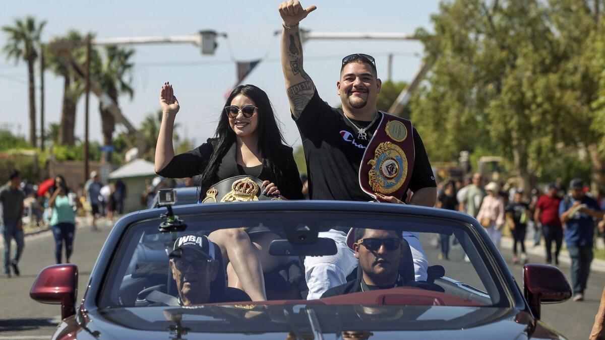Heavyweight boxing champion Andy Ruiz Jr. and his wife, Julie, wave to a cheering crowd during a parade for Ruiz this month in his hometown of Imperial, Calif.