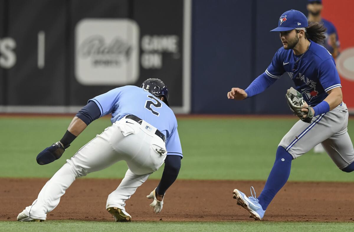 Toronto Blue Jays shortstop Bo Bichette, right, runs down Tampa Bay Rays' Yandy Diaz, left, for an out during the seventh inning of a baseball game Sunday, July 11, 2021, in St. Petersburg, Fla.(AP Photo/Steve Nesius)