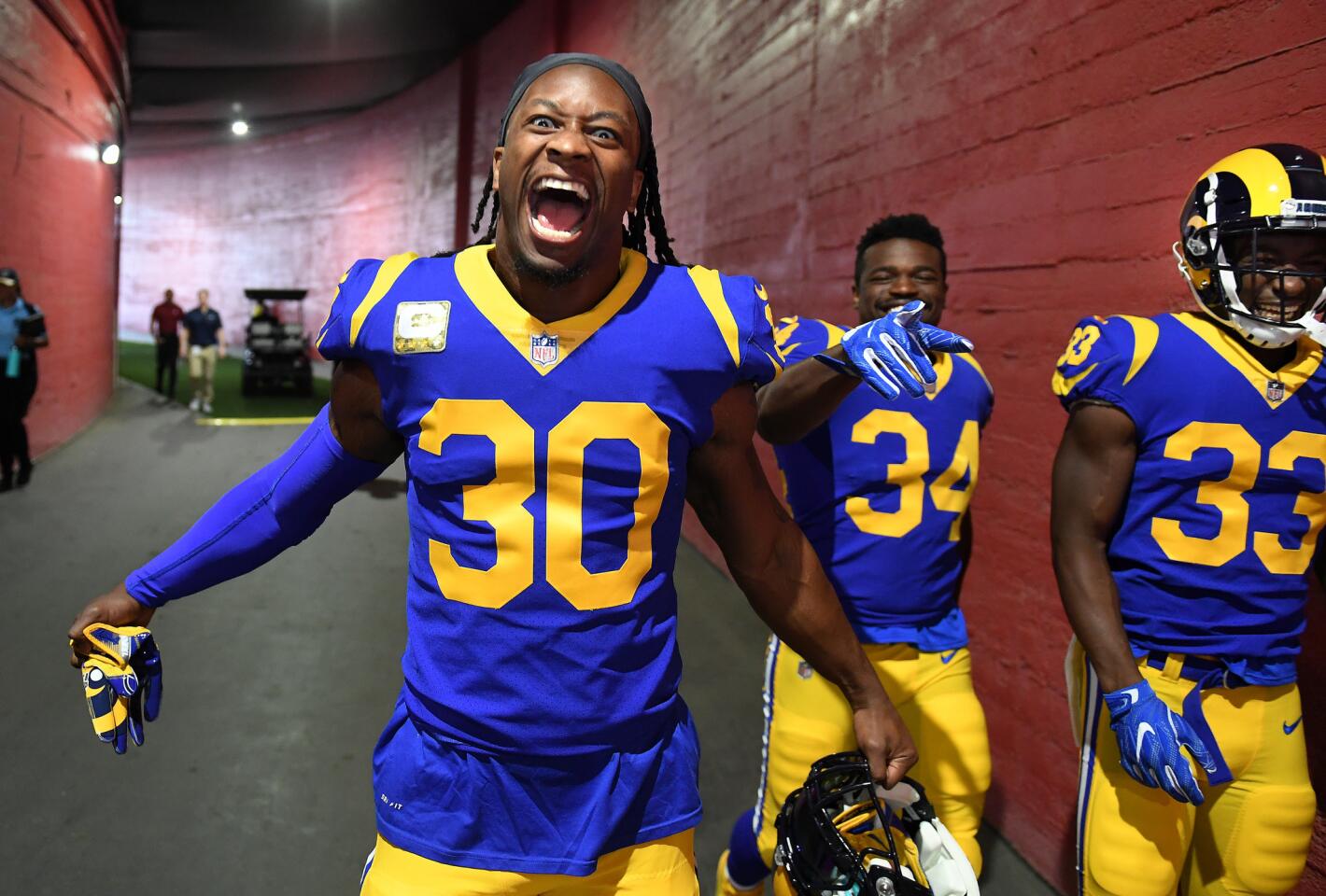 Rams running backs from left, Todd Gurley, Malcolm Brown and Justin Davis walk to the field before a game with the Seattle Seahawks at the Coliseum on Sunday.
