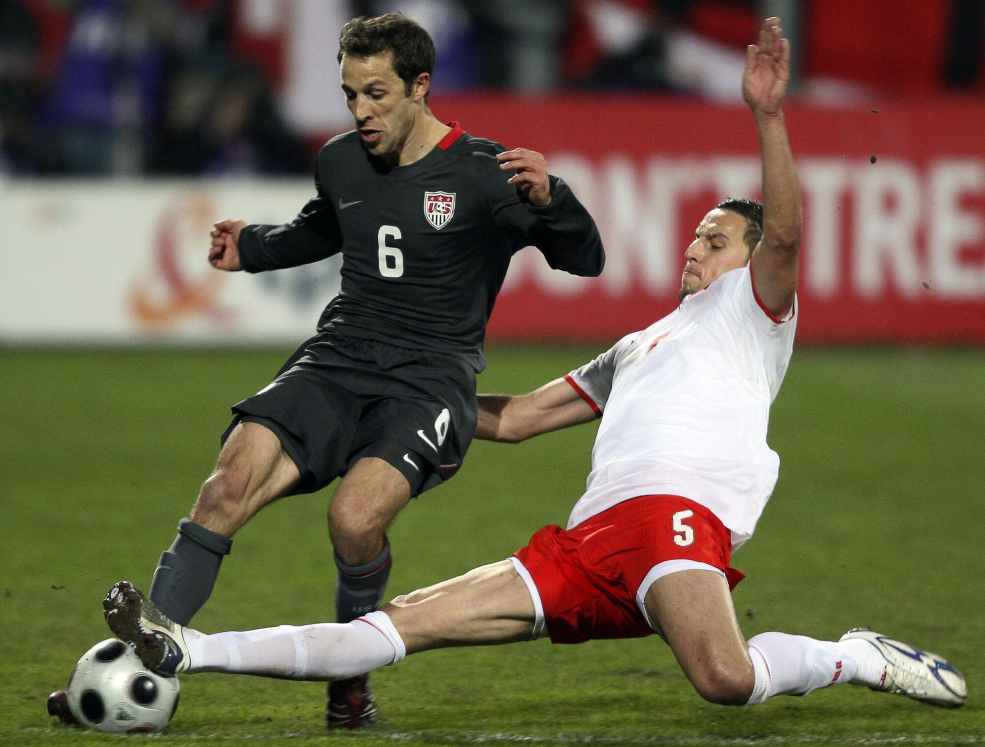 Steve Cherundolo and Dariusz Dudka challenge for the ball during a 2008 match between Poland and the U.S. 