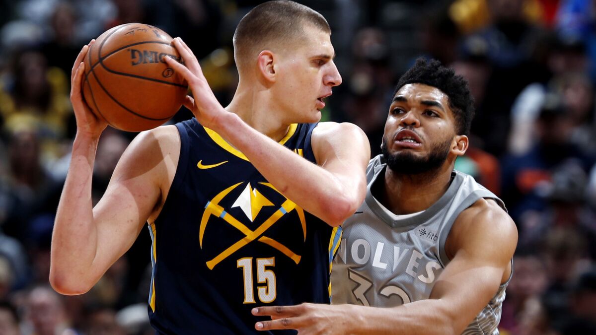 Nuggets center Nikola Jokic protects the ball from the reach of Timberwolves center Karl-Anthony Towns during a game Thursday.