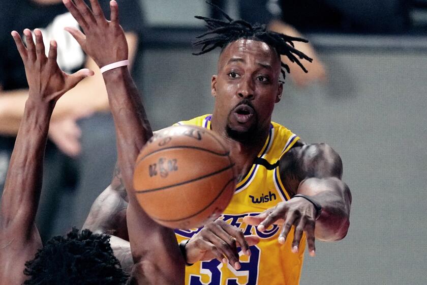 Los Angeles Lakers' Dwight Howard (39) passes the ball while pressured by the Miami Heat.