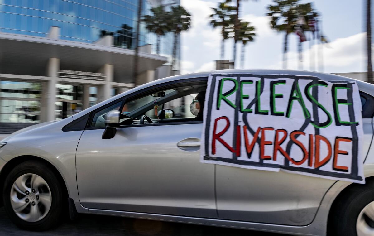 A car with a "release Riverside" sign on it