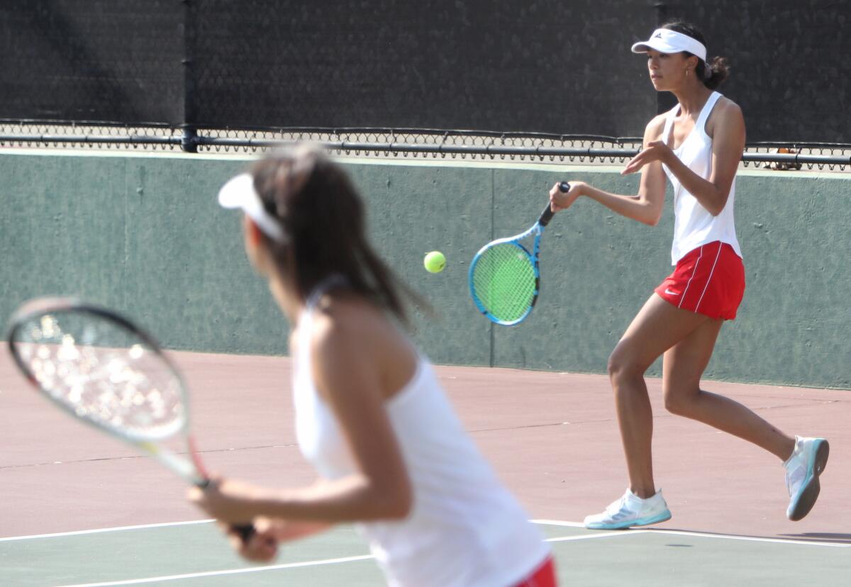 Burroughs High School girls’ tennis doubles player Suzy Kim returns the serve in home match vs. Glendale High School in Burbank, on Tuesday, Sept. 10, 2019.