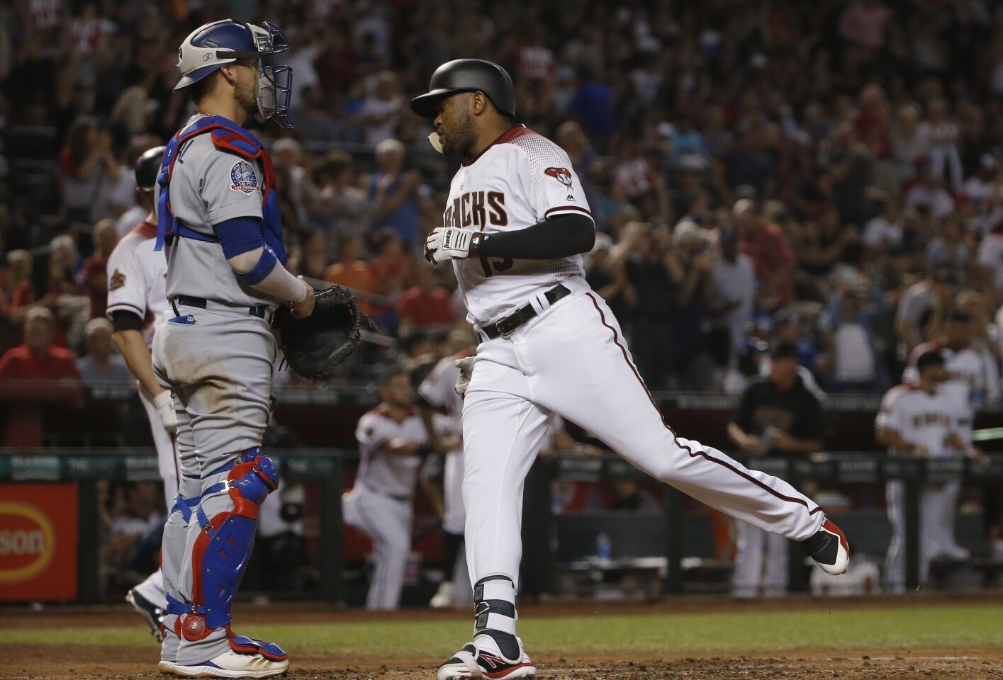 Arizona Diamondbacks' Socrates Brito, right, crosses home plate after hitting a home run as Los Angeles Dodgers catcher Yasmani Grandal, left, stands by during the second inning of a baseball game Wednesday, Sept. 26, 2018, in Phoenix. (AP Photo/Ross D. Franklin)