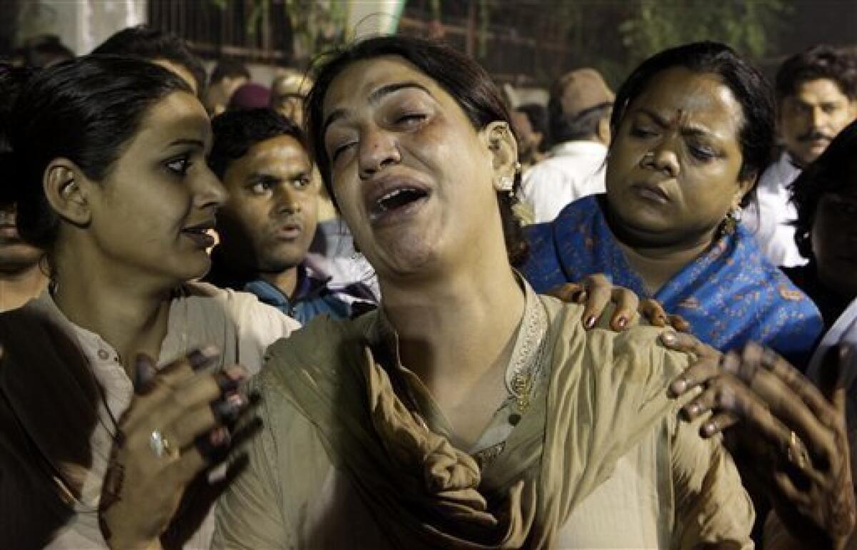 A eunuch cries as others console her at the site of fire which tore through a makeshift tent during a gathering of some thousands of eunuchs in New Delhi, India, Sunday, Nov. 20, 2011. The fire tore through the gathering of thousands of eunuchs in the Indian capital on Sunday, killing at least 13 people and injuring dozens of others, police said. (AP Photo/ Manish Swarup)
