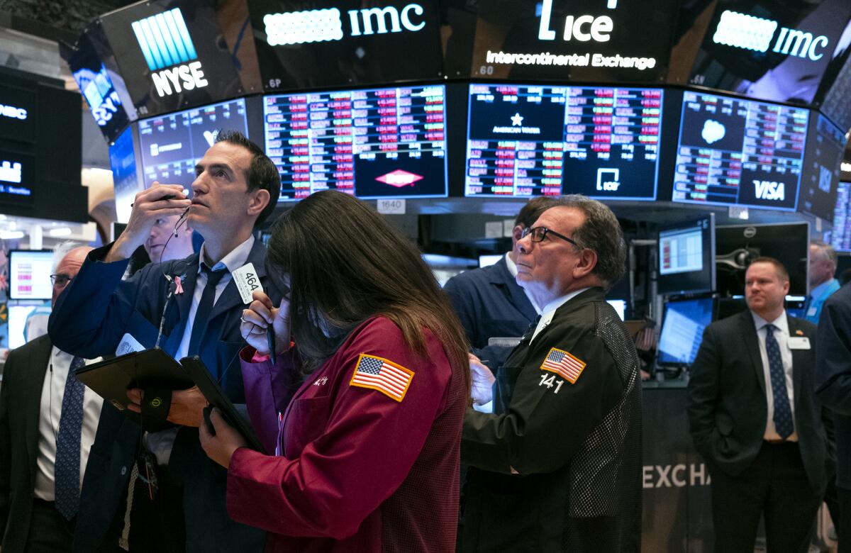 Traders work on the floor of the New York Stock Exchange. School officials poised to sell $30 million of Measure LCF school bonds decided to hold off, after a dizzying stock market response to the coronavirus pandemic shook the municipal bond market.