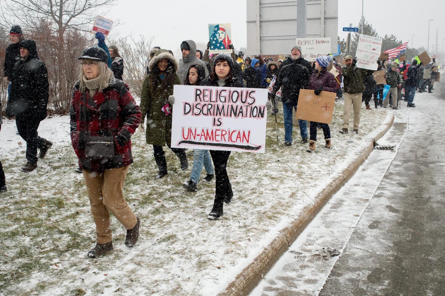People march during a protest against an executive order on immigration from President Trump at Gerald R. Ford International Airport in Grand Rapids on Sunday, Jan. 29, 2017.