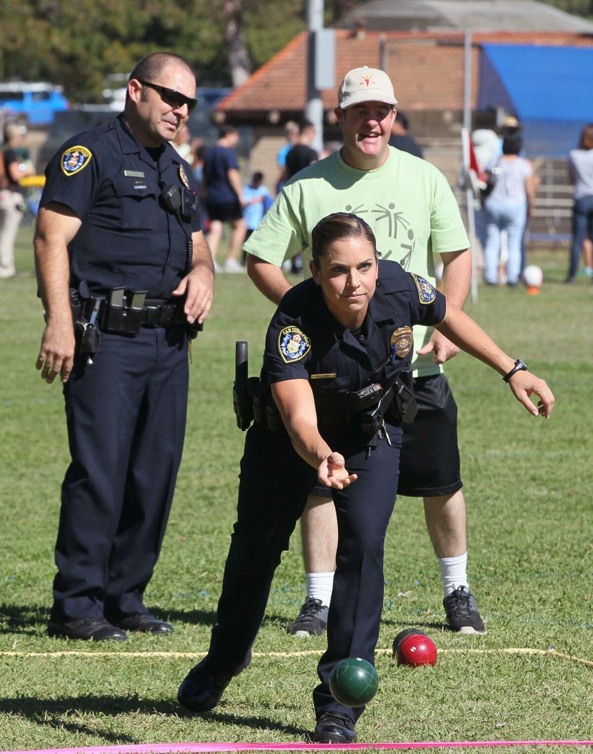 November 7, 2015_San Diego, California_USA_| At Rancho Bernardo Recreation Park San Diego Police Officer Jacki Lowry rolls a bocce ball during bocce ball competition at the San Diego County Regional Fall Games of the Special Olympics. Watching are teammates Officer Vito Messineo, left, and Special Olympics athlete Billy Lockett. |_Mandatory Photo Credit: Photo by Charlie Neuman/San Diego Union-Tribune/©2015 San Diego Union-Tribune, LLC San Diego Union-Tribune