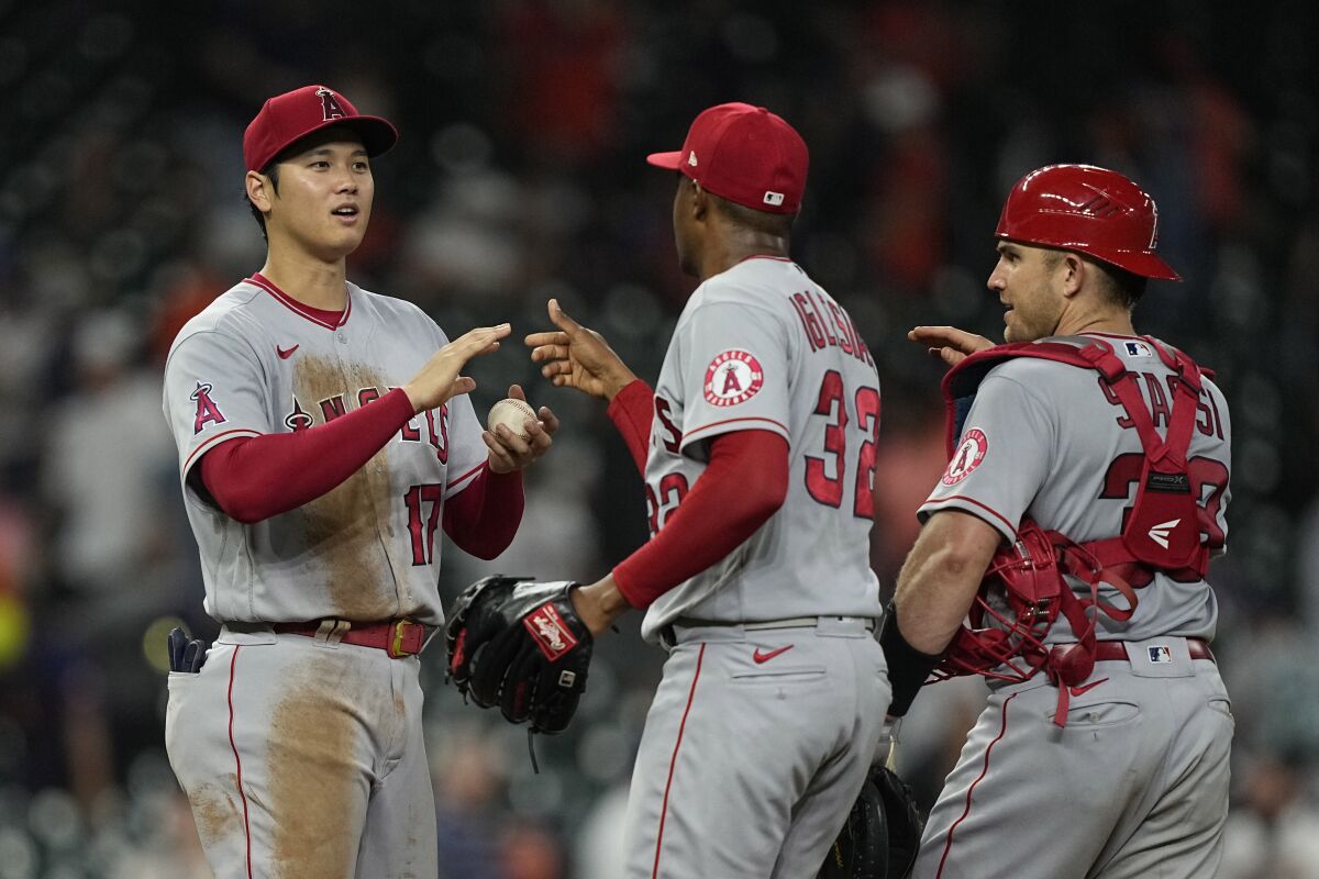 Shohei Ohtani, left, celebrates the Angels' victory over the Astros on Wednesday with Raisel Iglesias (32) and Max Stassi. 