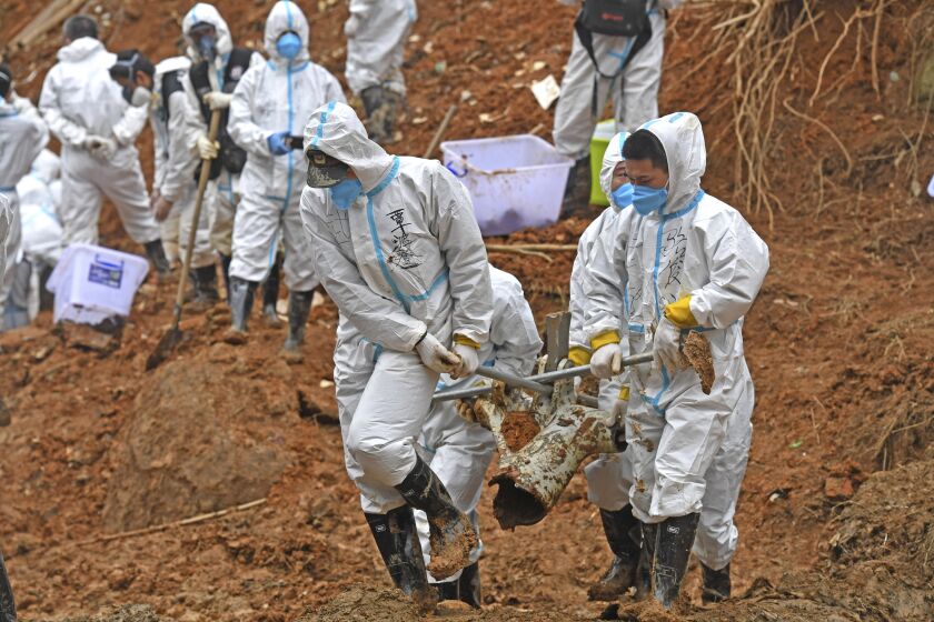 FILE - In this photo released by Xinhua News Agency, rescuers carry a piece of plane wreckage from the China Eastern flight crash site in Tengxian County, southern China's Guangxi Zhuang Autonomous Region, on March 25, 2022. Chinese officials said Thursday that the search for wreckage in last week's crash of a China Eastern Boeing 737-800 is basically done and that more than 49,000 pieces of debris had been found. (Zhou Hua/Xinhua via AP, File)