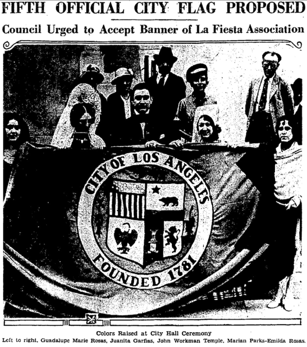 Black and white photo shows people holding the L.A. city flag
