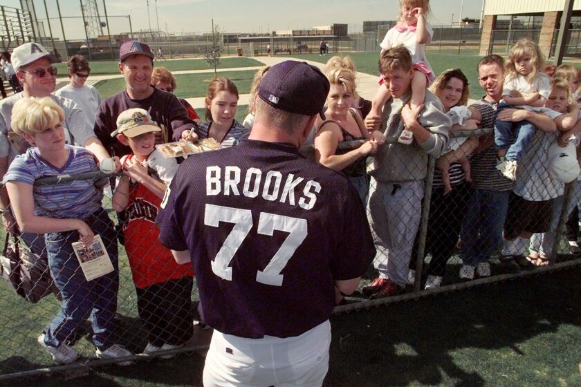 Garth Brooks, a non–roster invitee to the San Diego Padres spring training camp, signs autographs following a workout in Peoria, Ariz., Saturday, Feb. 21, 1999. Fences to keep fans back and special restrictions for media members have been added to the Padres camp because of the celebrity statusof Brooks. (AP Photo/Elaine Thompson)