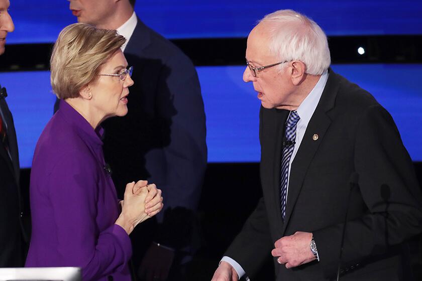 Elizabeth Warren and Bernie Sanders speak after the Democratic presidential primary debate at Drake University on Tuesday.
