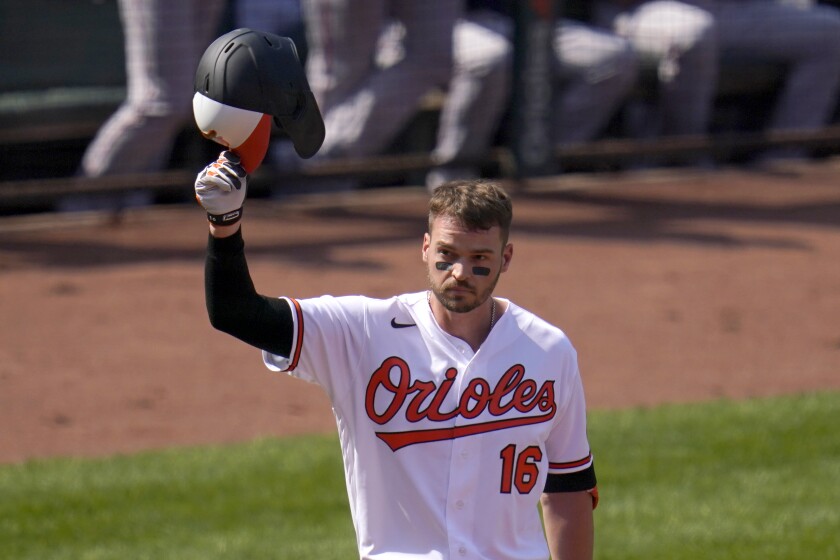 Baltimore Orioles' Trey Mancini tips his helmet as fans give him a standing ovation prior to batting against the Boston Red Sox during the first inning of a baseball game, Thursday, April 8, 2021, on Opening Day in Baltimore. (AP Photo/Julio Cortez)