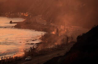 Houses smolder from the Palisades fire on Pacific Coast Highway in Malibu.