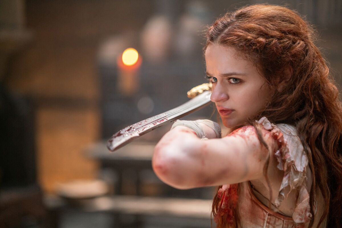 A young woman wields a bloody sword.