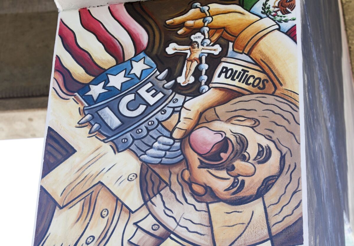 A detail of a mural at Chicano Park in San Diego shows a worker being oppressed by both sides of the border.