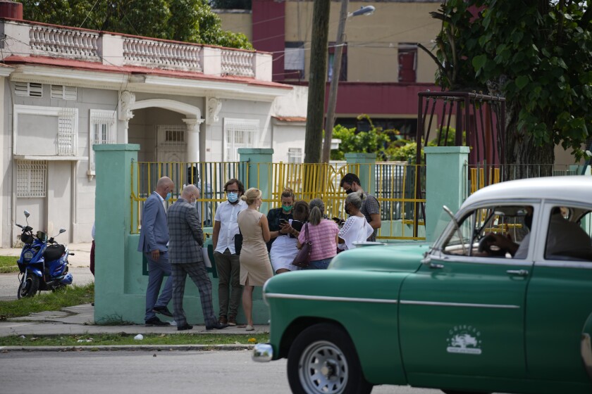 Diplomats from several countries wait outside the court building where a trial is going on for Cuban artists Luis Manuel Otero Alcantara and Maykel Castillo in Havana, Cuba, Monday May 30, 2022. The artists were arrested and imprisoned in connection with alleged public disorder at a community event they hosted in April 2021. (AP Photo/Ramon Espinosa)