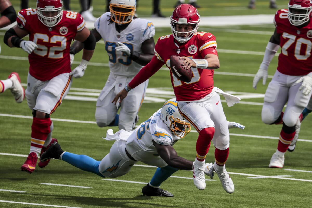 Kansas City Chiefs quarterback Patrick Mahomes runs past diving Chargers linebacker Kenneth Murray.