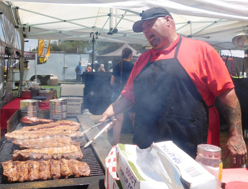 Ο ιδιοκτήτης του Meat Monsters Grill Anthony Andrews ετοιμάζει ένα γλέντι στη σχάρα στον πάγκο φαγητού του.