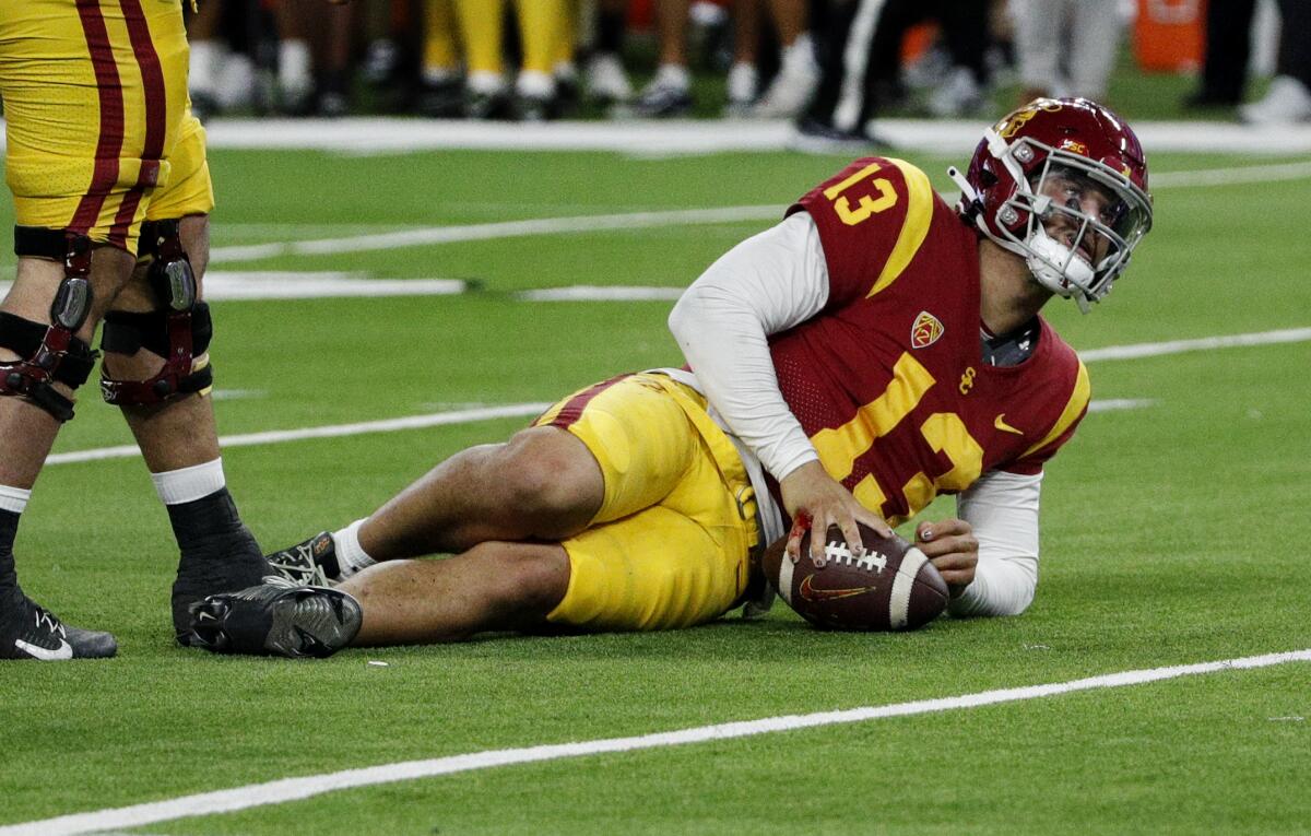 USC quarterback Caleb Williams slowly gets up with a bloodied right hand.