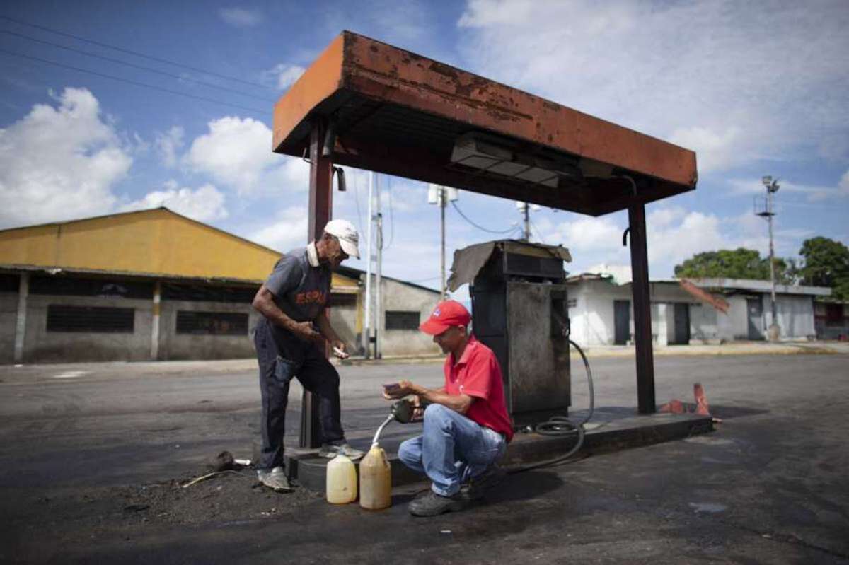 Un dependiente llena garrafas de plástico con gasolina en Chivacoa, Venezuela. La gasolina es tan barata que los dependientes no saben el precio y a algunos conductores sin dinero se les permite irse sin pagar.