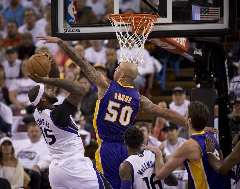 Kings center DeMarcus Cousins is fouled as Lakers center Robert Sacre makes a block in the first half.