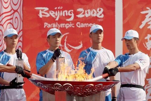 The Paralympic flame is lit by Chinese security personnel to begin the torch relay segment at the Millennium Monument in Beijing, China.