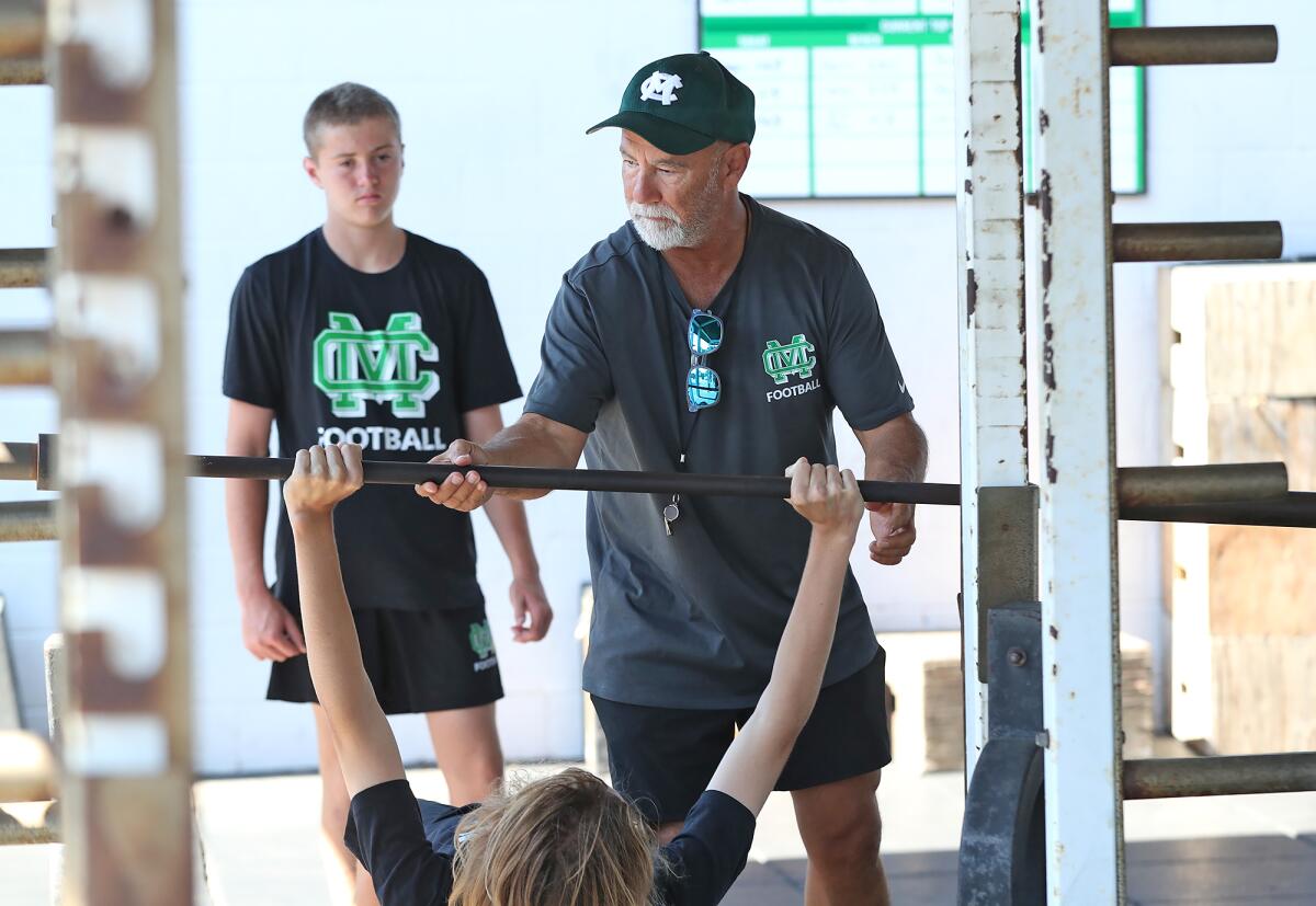 Former Costa Mesa City Manager Tom Hatch on Tuesday works with Costa Mesa High's freshman football team in summer practice.