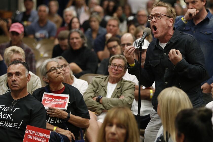 VENICE, CA-OCTOBER 17, 2018: Anthony Wells, right, a Venice resident for the past 30 years, voices his opposition to Mayor Eric Garretti, Councilman Mike Bonin and LAPD Police Chief Michel Moore during a town hall at Westminster Elementary School in Venice, to discuss plans to put a homeless shelter in a vacant MTA lot in Venice. Wells asked them why all the money is being spent on short term beds when they could be spending it instead on putting people into pre-existing homes, which he believes is far less expensive. (Mel Melcon/Los Angeles Times)