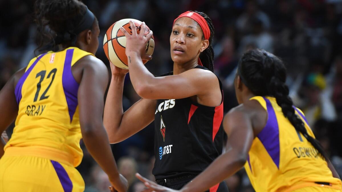 Aces center A'ja Wilson looks to pass against the double-team defense of the Sparks' Chelsea Gray and Chiney Ogwumike during the first half Sunday.