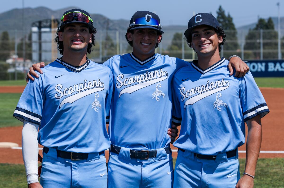 Camarillo's Tostado triplets stand beside each other in light blue baseball uniforms