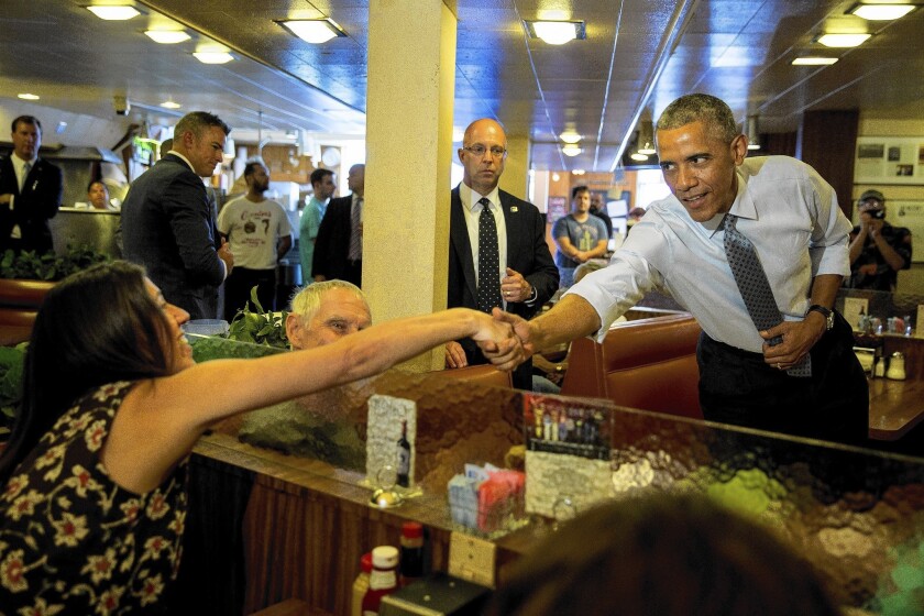 President Obama shakes hands with a patron inside Canter's Deli in the Fairfax district before having lunch with a few supporters.