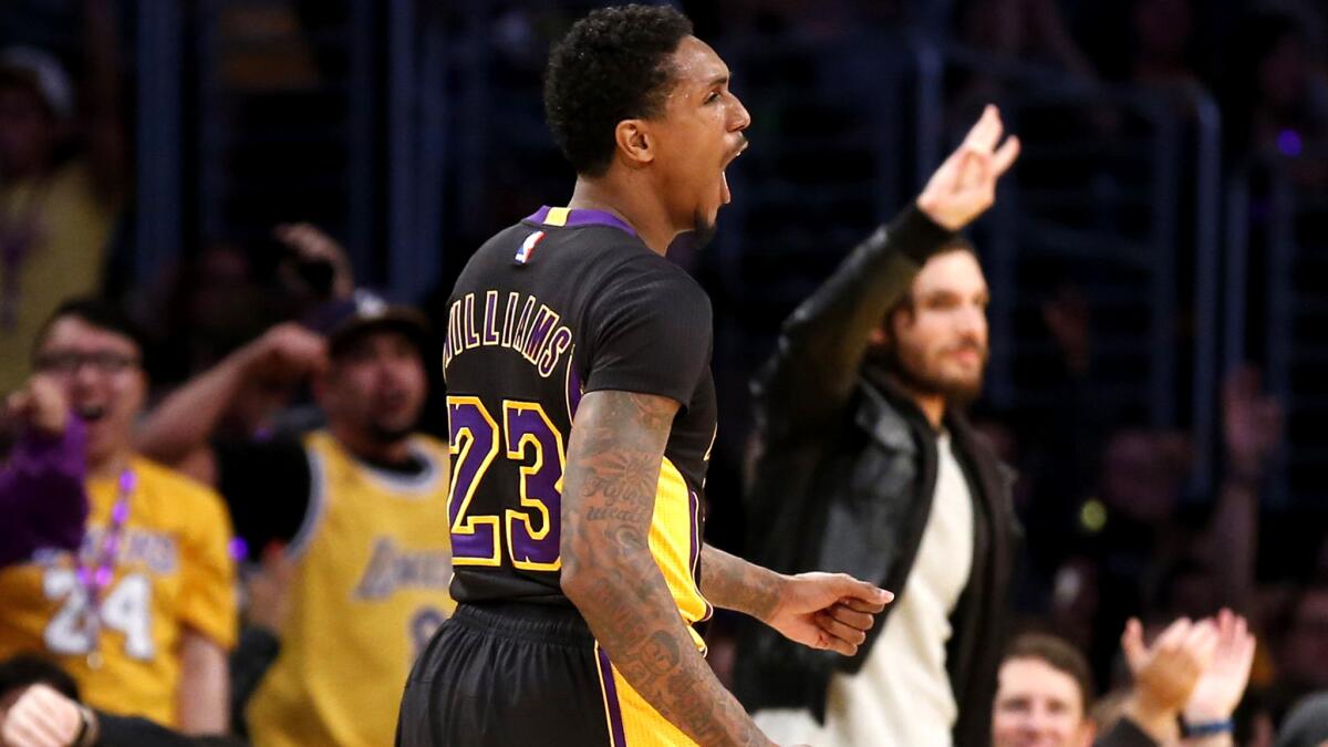 Lakers guard Lou Williams joins a few fans to celebrate after making a three-pointer against the 76ers in the second half Friday night. Williams was the game's leading scorer with 24 points.