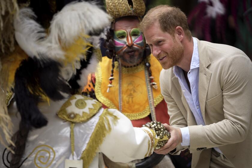 El príncipe Enrique saluda a un bailarín tradicional del carnaval durante una ceremonia de bienvenida en el Centro Nacional de las Artes Delia Zapata, el jueves 15 de agosto de 2024, en Bogotá, Colombia. (AP Foto/Iván Valencia)