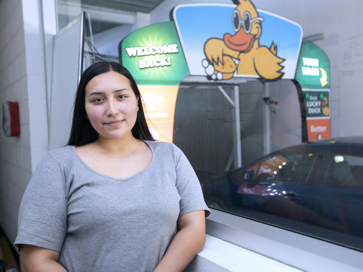 Priscilla Perez, recently homeless, stands at her place of employment, Quick Quack Car Wash in Anaheim.