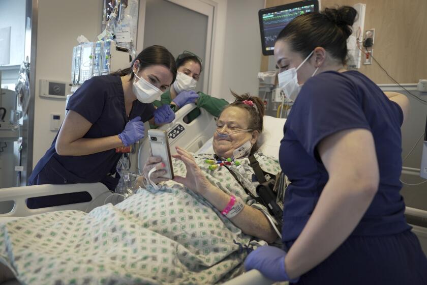 Lisa Pisano mira fotos de su perro después de ser operada en el hospital NYU Langone Health en Nueva York, 22 de abril de 2024. Los médicos transplantaron un rión de cerdo a Pisano, quien se hallaba al borde de la muerte. (AP Photo/Shelby Lum)
