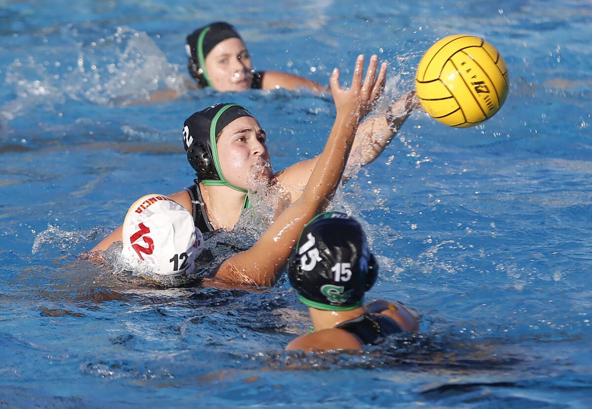 Costa Mesa's Kenzie Mora (2) knocks the ball away for a steal during Battle for the Bell girls' water polo game.