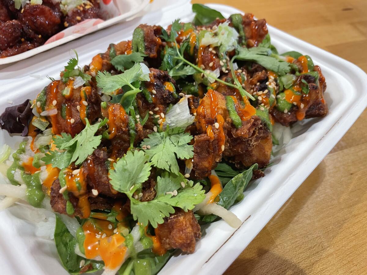 Fried chicken with cilantro in a takeout container.