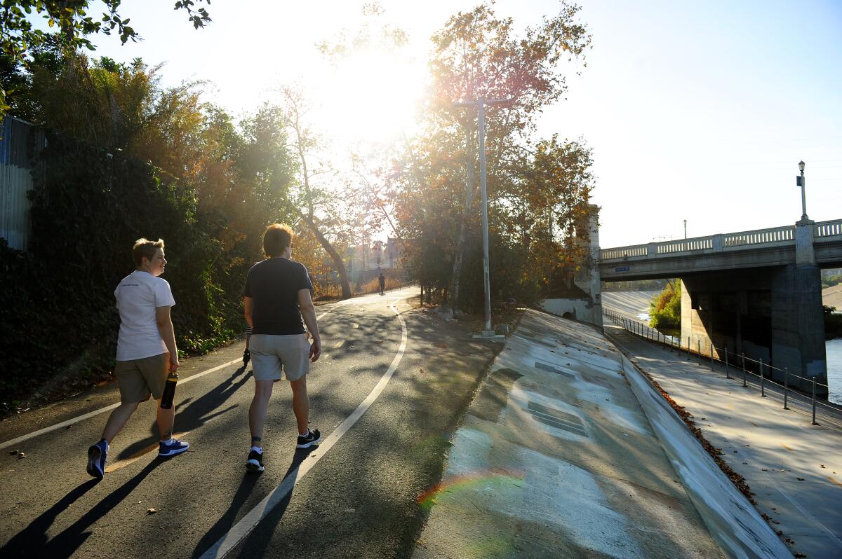 Pedestrians walk along the Los Angeles River in Frogtown