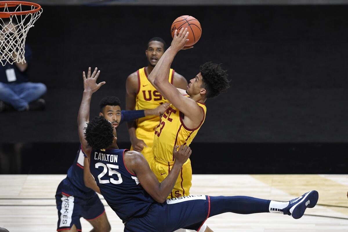 Connecticut's Josh Carlton fouls USC's Max Agbonkpolo during the first half.