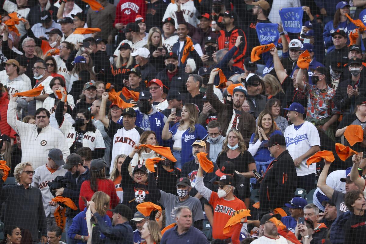 Dodger fans stand amid chanting San Francisco Giants fans before the start of Game 2 of the NLDS on Saturday.