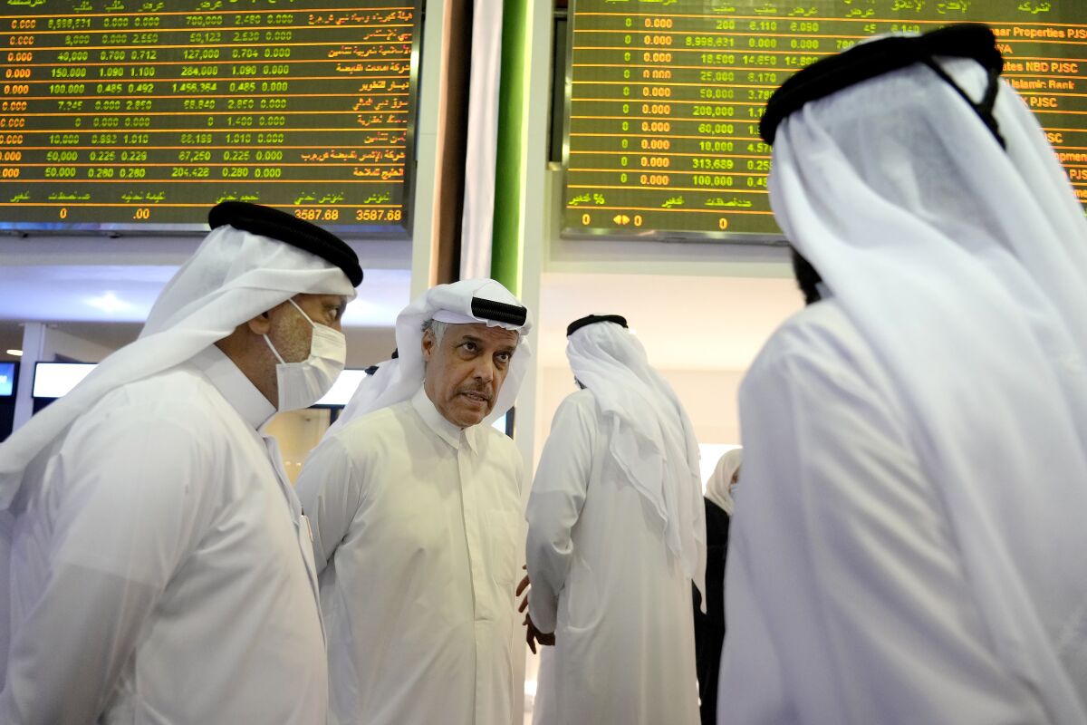 Emirati traders wait for the listing of DEWA on the floor of the Dubai Financial Market in Dubai, United Arab Emirates, Tuesday, April 12, 2022. Dubai's Water and Electricity Authority, known as DEWA, began trading for the first time after raising just over $6 billion during its initial public offering, making it the second largest offering ever in the Middle East. (AP Photo/Ebrahim Noroozi)